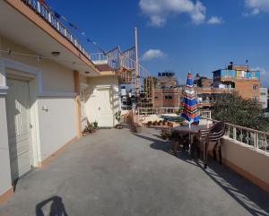 加德满都Rooftop Studio and 2BHK Apartments in Kathmandu's most happening place的阳台的天井配有桌椅