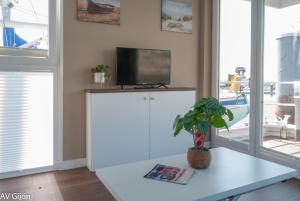 希洪AV Amsterdam Casa Flotante的客厅配有电视和白色桌子。