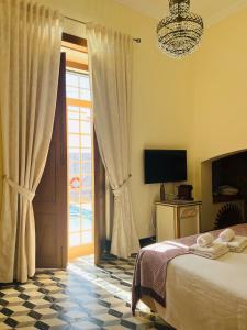 库巴Cuba Real的一间卧室设有一张床、一台电视和一个窗口。