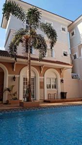 当格浪Aleena's Guesthouse BSD City的游泳池前有棕榈树的房子