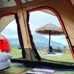 金塔马尼Kintamani Adventure Hidden Lodge的坐在帐篷内,享有美景的人