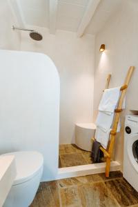 伊奥斯乔拉Heliopetra Punta的浴室配有卫生间、盥洗盆和洗衣机。