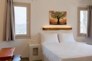 伊奥斯乔拉Heliopetra Punta的卧室配有一张挂在墙上的树画床。