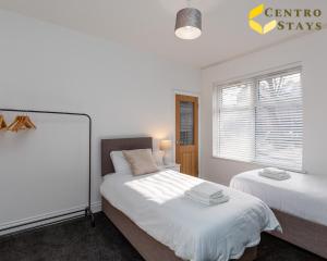 北安普敦Relocation Families Contractors FREE PARKING的一间卧室设有两张床和窗户。