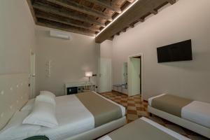 曼托瓦Ca' Tazzoli的一间卧室配有两张床和一台平面电视