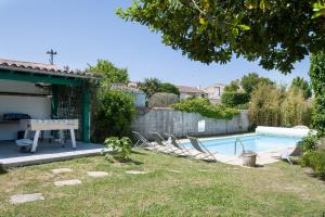 雷岛林滩Maison Ma Ré Hôtes的后院设有游泳池、桌子和椅子