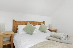 OakamoorLuxurious Barn Conversion的卧室配有带绿色枕头的白色床