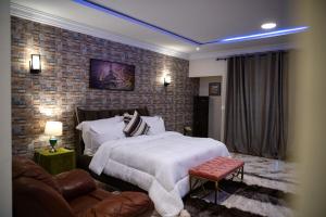 阿克拉Brynx Haven - Adenta, Accra的一间卧室设有一张大床和砖墙