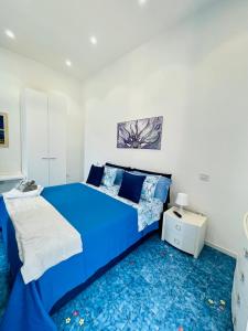 埃尔基耶Il Sogno的蓝色的床铺,位于白色的房间里,铺有蓝色的地毯