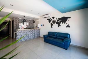 普拉亚卡门Hotel Ambra的客厅配有蓝色的沙发和墙上的世界地图