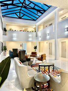 圣布鲁诺Hotel Aluxor SFO, Sapphire Boutique Collection的大堂设有沙发和桌子,拥有蓝色的天花板
