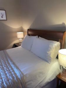 斯佩河畔格兰敦Brooklynn Guest House的卧室内的一张带白色床单和枕头的床