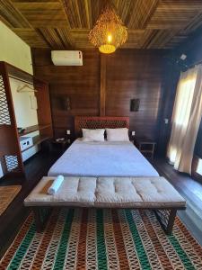 阿廷斯Atins Charme Chalés的木制客房内的一间卧室配有一张大床
