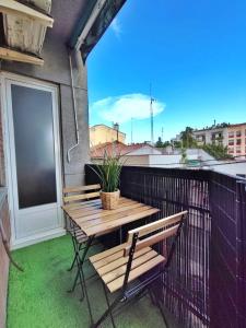 萨瓦德尔LG DownTown Sabadell Apartment的阳台设有木桌和长凳,配有窗户