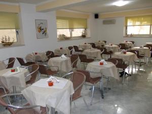 罗迪-加尔加尼科索拉丽亚酒店的配有桌椅和白色床单的房间