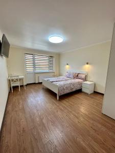 古尔贝内Swan City Family Apartment的一间卧室配有一张床,铺有木地板