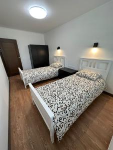 古尔贝内Swan City Family Apartment的铺有木地板的客房内的两张床