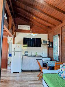 因比图巴Chalés Praia do Rosa piscina compartilhada的厨房配有白色冰箱和桌子