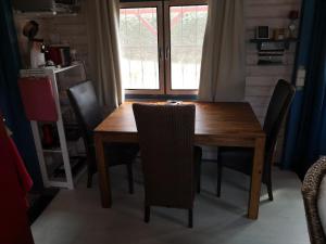 KamminkeRotes Haus Usedom的木制用餐室配有桌椅和窗户