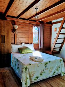 因比图巴Chalés Praia do Rosa piscina compartilhada的一间卧室设有一张带木制天花板的大床