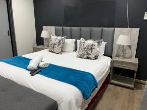 LeribeEmpire Bed & Breakfast的一间卧室配有一张带蓝色毯子的大床