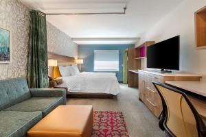 班戈Home2 Suites by Hilton Bangor的配有一张床和一台平面电视的酒店客房