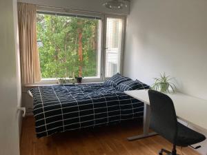 埃斯波Tapiola Hill Apartment 2 bedroom and 1 living with private parking的一间卧室配有一张床、一张书桌和一个窗户。