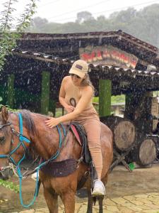 博尼托Pousada Toca da Coruja的一位在雨中骑着马的女人