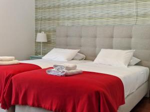 法鲁Guest House do Largo的一间卧室配有两张带红色毯子的床