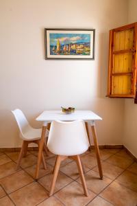 伊亚Ostria Caldera Studios的客房内的一张白色桌子和两把白色椅子