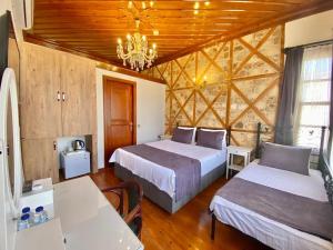 安塔利亚Necip Bey Konağı的一间卧室配有两张床和吊灯。