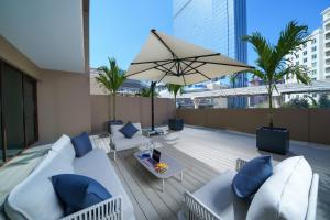 迪拜仕骅廷迪拜棕榈岛梅森酒店的屋顶庭院配有沙发和遮阳伞。