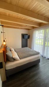 坦海姆Mountain Moments Tannheim - Familie Weber的卧室内的一张大床,拥有木制天花板