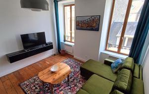 莫尔莱Au Fil de soi的客厅配有绿色沙发和桌子