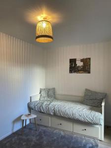 蒙蒂尼布勒托讷Studio 28 m2 & jardin privatif 20 m2的一间卧室配有一张带台灯和桌子的床