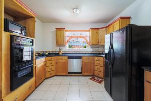 圣詹姆斯Ferron House的厨房配有木制橱柜和黑色冰箱。