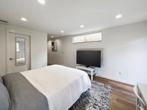 西雅图Modern apartment near light rail的一间卧室配有一张大床和一台平面电视