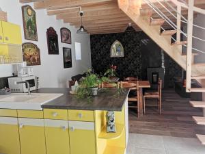 PlouigneauLes gîtes de L'hermine的一间厨房,配有黄色橱柜和一间餐厅