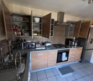 米尔顿凯恩斯Keniji Luxury 2 Bed Apartment的厨房配有水槽和炉灶 顶部烤箱