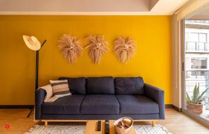 墨西哥城Casa Vive Grand by Kukun的带沙发和黄色墙壁的客厅