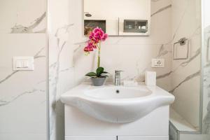 马卡尼奥Casetta Lago Maggiore的白色的浴室,配有水槽和花