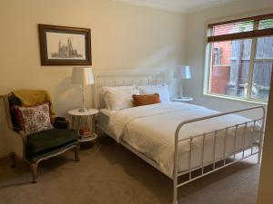 本迪戈Luxury Inner City Townhouse的卧室配有床、椅子和窗户。