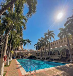 巴兰基亚草原酒店的一座楼前棕榈树游泳池