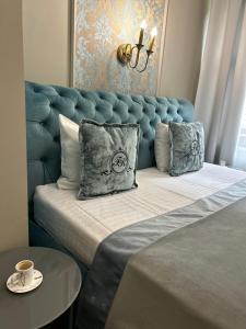 利沃夫Family Residence Boutique Hotel的一张带蓝色床头板和枕头的床