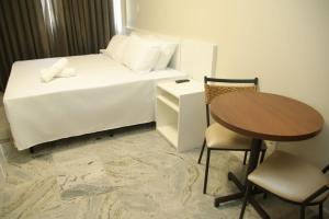 贝洛奥里藏特Rede Andrade Pampulha的酒店客房,配有一张床、一张桌子和椅子