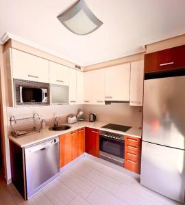 格拉纳迪利亚德亚沃纳3-bedrooms apartament Vista Roja的厨房配有白色橱柜和不锈钢冰箱