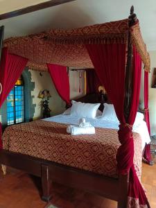 维纳德马卡斯蒂略中世纪酒店的一间卧室配有一张带红色窗帘的天蓬床