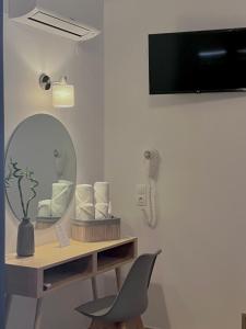 斯基亚索斯镇ATHANASIA APARTMENTS的客房设有镜子、书桌和椅子