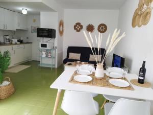 卡勒达德福斯特Charmant Appartement Casa Freesia Caleta avec piscine的厨房里配有白色的桌子和椅子
