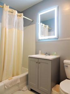 格罗顿温莎汽车旅馆的一间带水槽、卫生间和镜子的浴室
